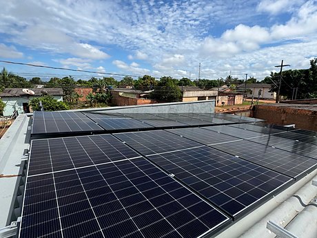 Módulos solares instalados em telhado, com céu aberto ao fundo