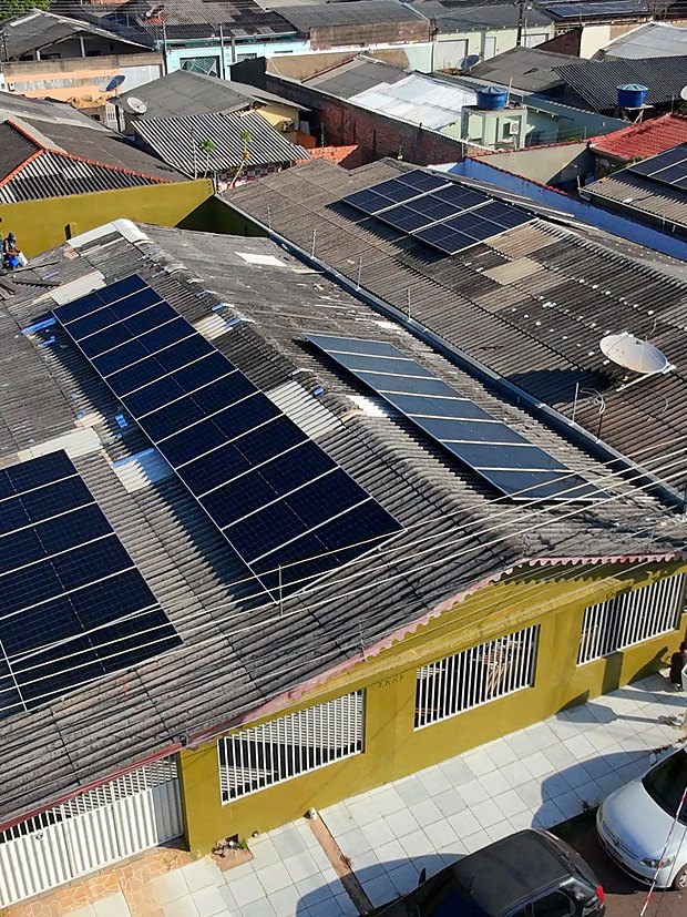 Vista aérea de residência com módulos solares instalados no telhado