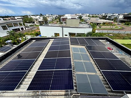 Módulos solares instalados em telhado plano de uma edificação